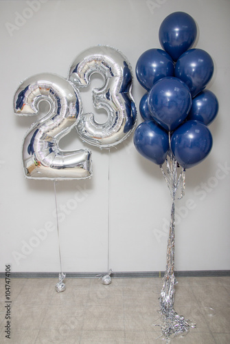 silver number 23 balloons and a bouquet of blue latex helium balloons