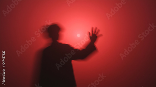 Silhouette of a guy on a red background with the sun behind his back, done in an abstract and artistic style