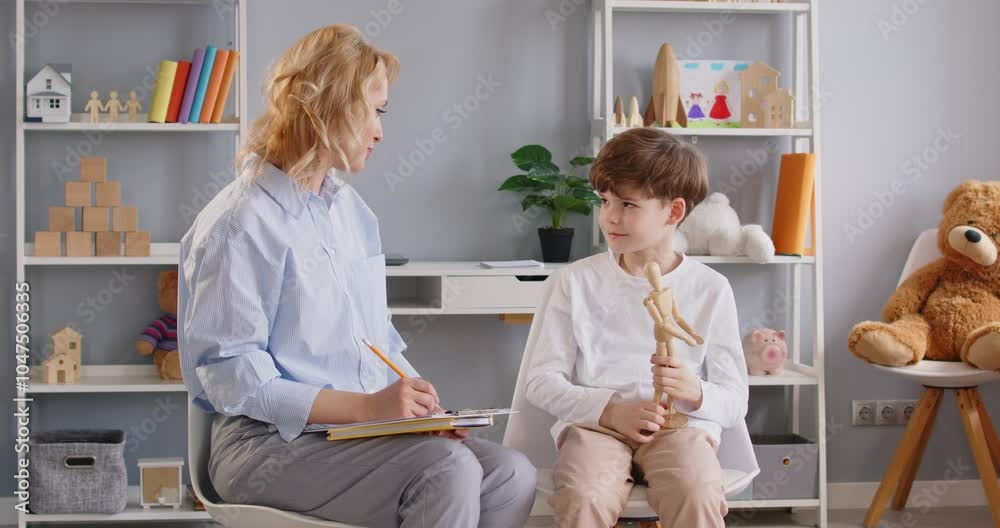 Child therapist, small preschooler boy, teacher, testing, evaluate, sharing problems. Caring attentive adult having trustful conversation, treating emotional and behavioral professional psychology