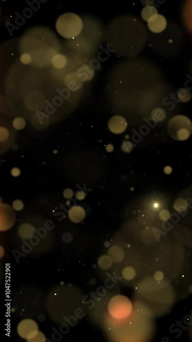 Vertical Golden Bokeh Particle Holiday Dance 4K Loop features a field of black with glowing yellow and gold blurred bokeh lights floating around in a vertical ratio loop.