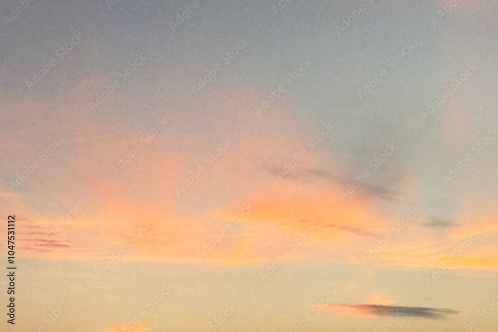 Obraz premium Beautiful sky during sunset or sunrise. The clouds are a perfect blend of warm orange and soft pink. The gradient makes this scene look calm and peaceful.