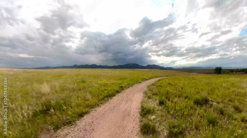 stunning bike trail on the field with typical landscape of grass and mountains in the background  near Denver
