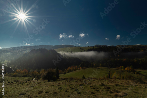 Autumn meadows and foggy valleys near mountain cottages near Jaworki village photo