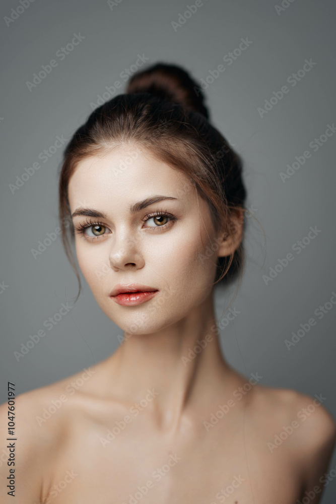 Portrait of a beautiful young woman with natural makeup on grey background Portrait of a beautiful young woman with natural makeup on grey background