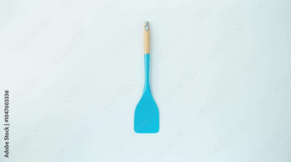 A single blue kitchen spatula is placed on a clean white surface, with vibrant lighting that enhances the colors and creates a fresh, appealing look.