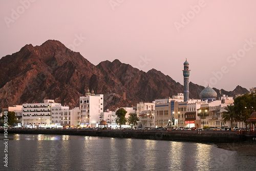 Panoramic view of Muscat Muttrah district with waterfront, traditional architecture in Oman during sunset