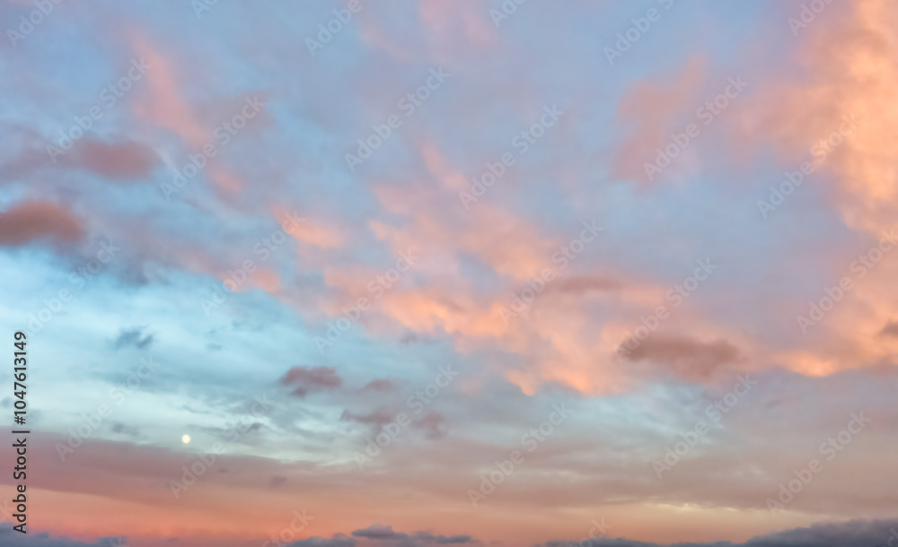 Obraz premium A beautiful sky tinted by the sun leaving vibrant shades of gold, pink, blue and multicolored. Clouds in the twilight evening and morning sky. Cloudy sky background in the evening, and during the day.