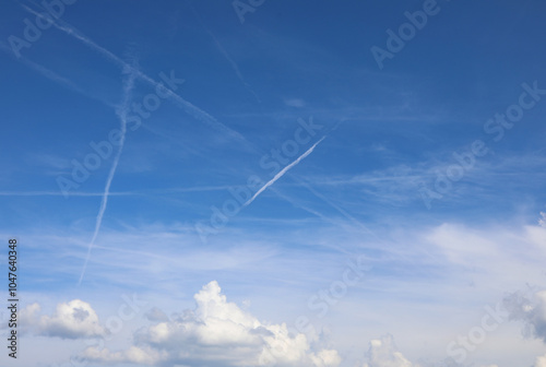 white chemtrails contrast against the blue sky and some people already think of a global conspiracy