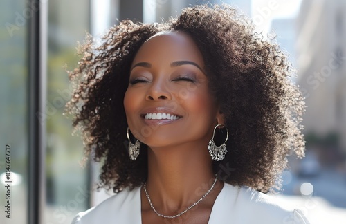 Woman with curly hair enjoys sunlight in a city street during a warm afternoon