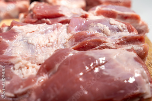 A close up of raw meat on a cutting board. The meat is cut into strips and he is fresh photo