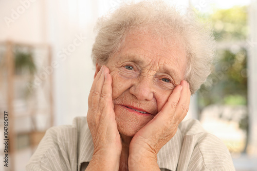 Portrait of beautiful senior woman against blurred background