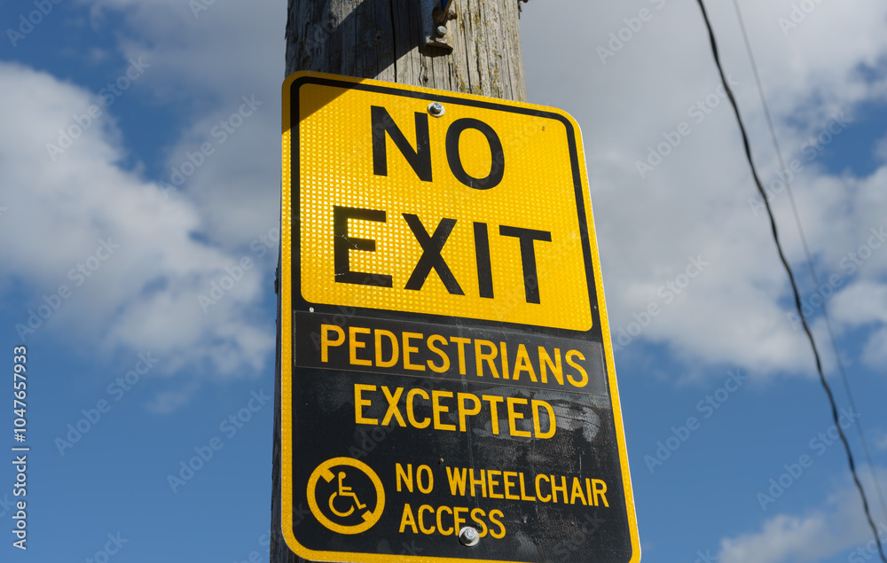 No Exit, Pedestrians Excepted, No Wheelchair Access sign on a utility pole and sky with clouds No Exit, Pedestrians Excepted, No Wheelchair Access sign on a utility pole and sky with clouds