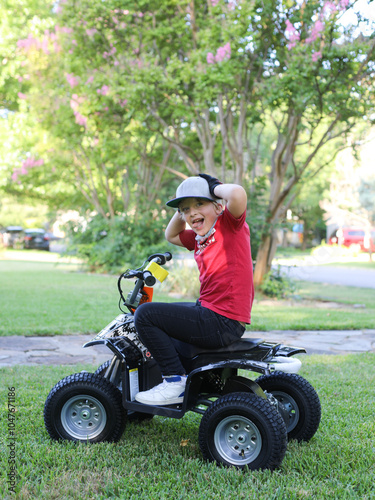 boy making a goofy face riding a four wheeler photo