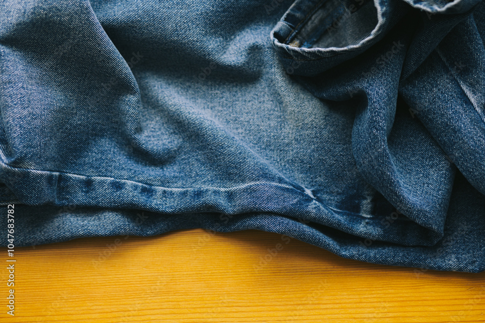 Fototapeta premium Close up of dark blue denim jeans on wooden background. Denim texture on wooden background