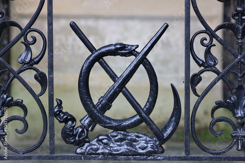 Obraz na płótnie decorative metal fence with scythe, Ouroboros and extinguished torch close up w salonie