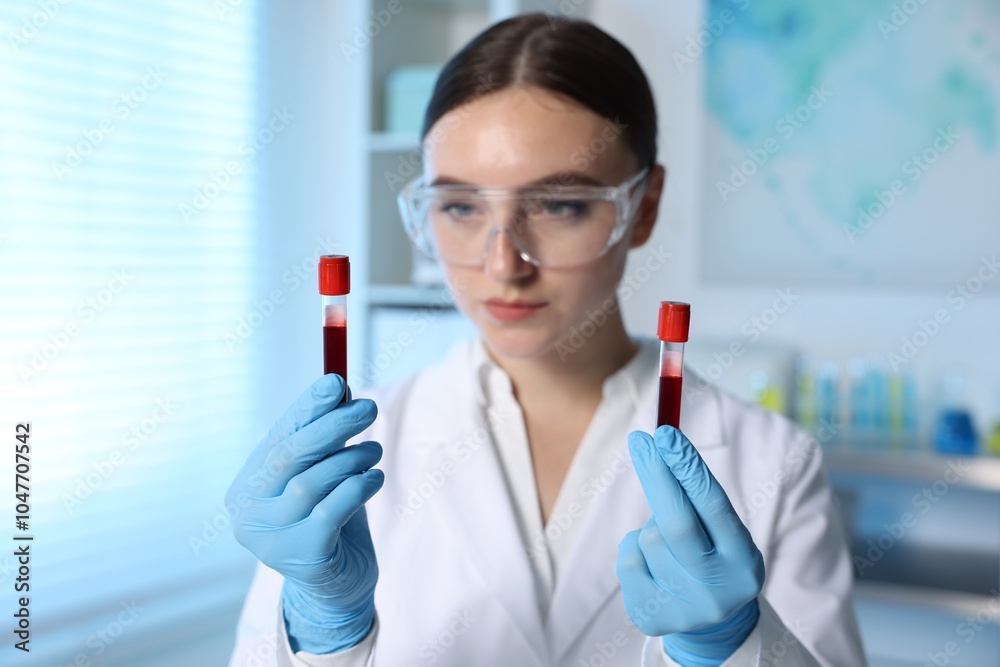 Laboratory testing. Doctor holding test tubes with blood samples indoors, selective focus Laboratory testing. Doctor holding test tubes with blood samples indoors, selective focus