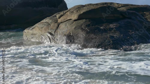 Slow-motion Shot of Waves Crashing on the Beach Rocks 4