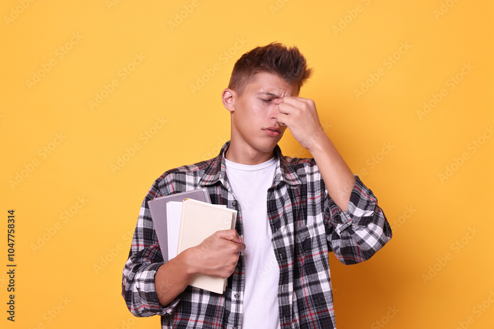 Young student with books having stress before exam on yellow background Young student with books having stress before exam on yellow background