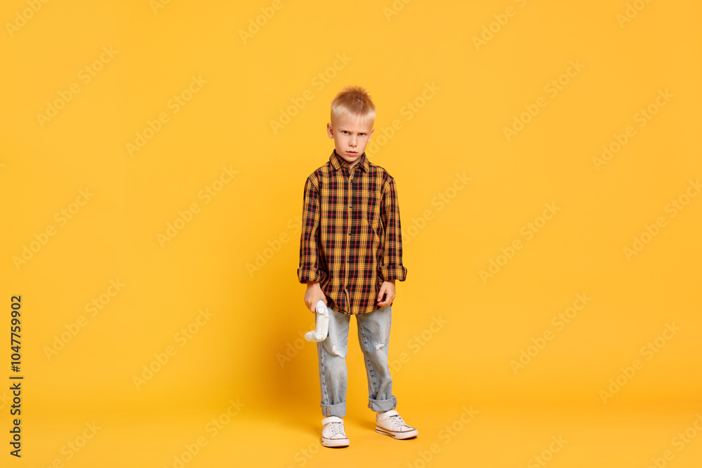 Little boy with controller on orange background Little boy with controller on orange background