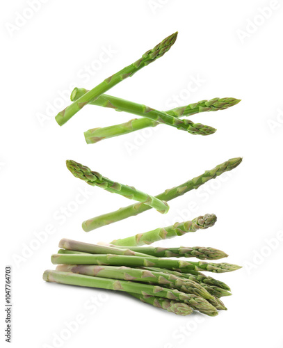 Fresh ripe asparagus falling on white background photo