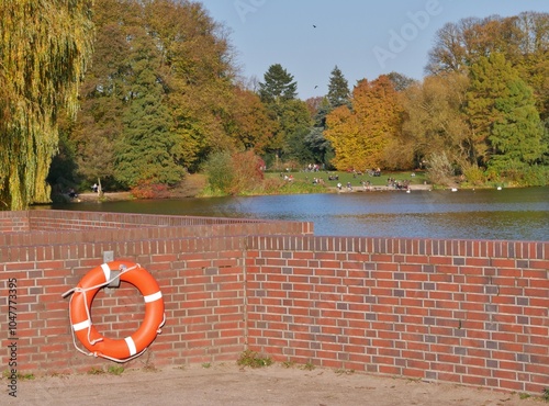 Mauer mit Rettungsring vor Stadtparksee photo