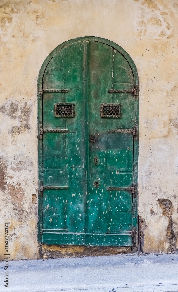 An old wooden blue door in a Mediterranean setting in a historic town in Italy.
