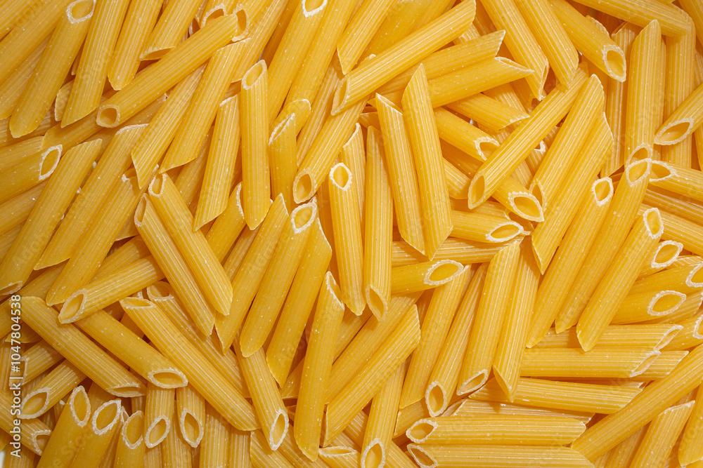 Uncooked Penne Rigate Pasta: A Culinary Canvas of Penne Macaroni, Creating a Lively and Textured Background for Gourmet Cooking. Dry Pasta. Raw Macaroni - Top View, Flat Lay Uncooked Penne Rigate Pasta: A Culinary Canvas of Penne Macaroni, Creating a Lively and Textured Background for Gourmet Cooking. Dry Pasta. Raw Macaroni - Top View, Flat Lay