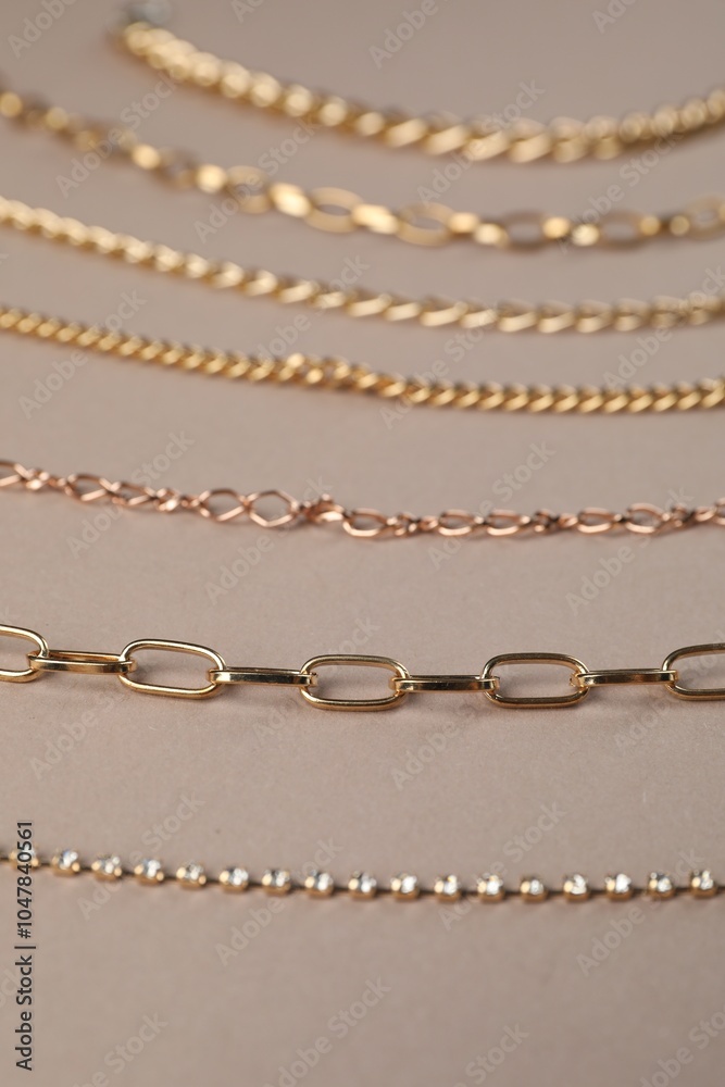 Different metal chains on light brown background, closeup. Luxury jewelry Different metal chains on light brown background, closeup. Luxury jewelry