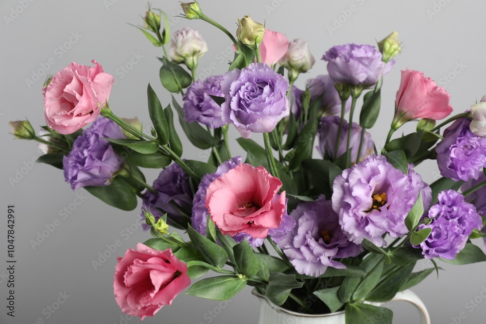 Vase with beautiful eustoma flowers near light grey wall, closeup Vase with beautiful eustoma flowers near light grey wall, closeup