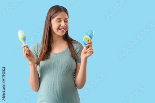 Beautiful pregnant woman with baby nibblers on blue background photo