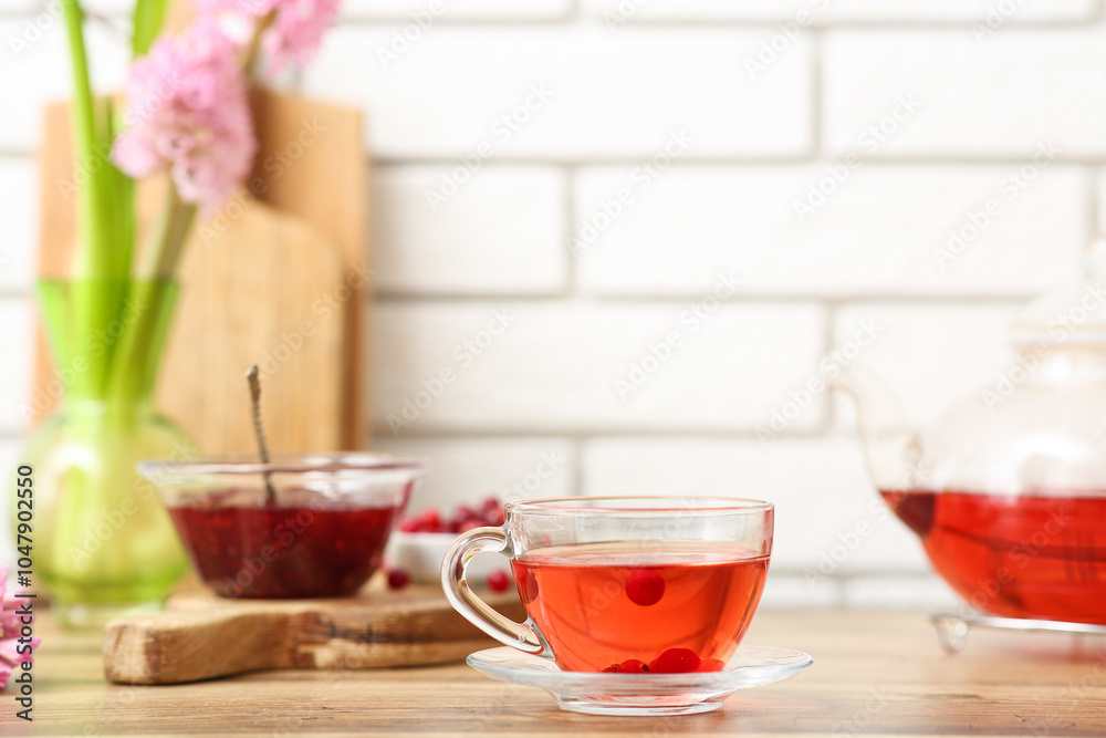 Cup of cranberry tea with cranberry jam on table in kitchen Cup of cranberry tea with cranberry jam on table in kitchen