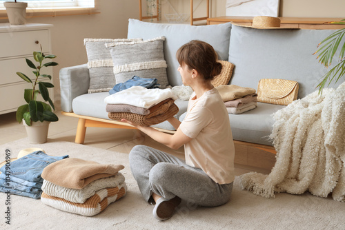 Woman folding clean clothes...