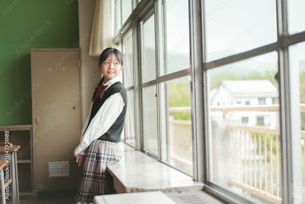 Fototapeta premium 教室で窓の外を見る日本人の女子中学生