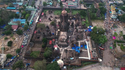 Aerial view of Lingaraj Temple complex: grand spire, ornate stonework, smaller shrines, dense greenery, festive crowds, and vibrant buildings surrounding the site. Odisha photo