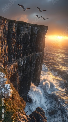 A breathtaking view of rugged cliffs at sunset, with seagulls soaring above tumultuous waves crashing against the rocks, creating a dramatic coastal scene. photo