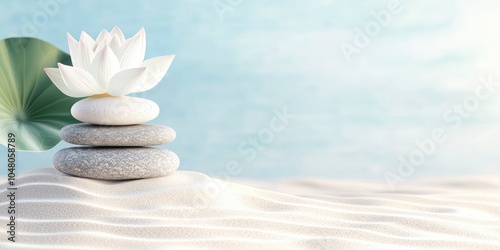 balanced stones, a lotus flower, and gentle ripples on the sand against light blue background