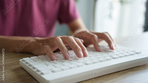 Hands man typing on white keyboard.