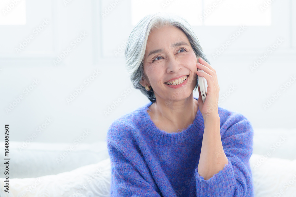 スマートフォンで通話をする中高年の女性 スマートフォンで通話をする中高年の女性