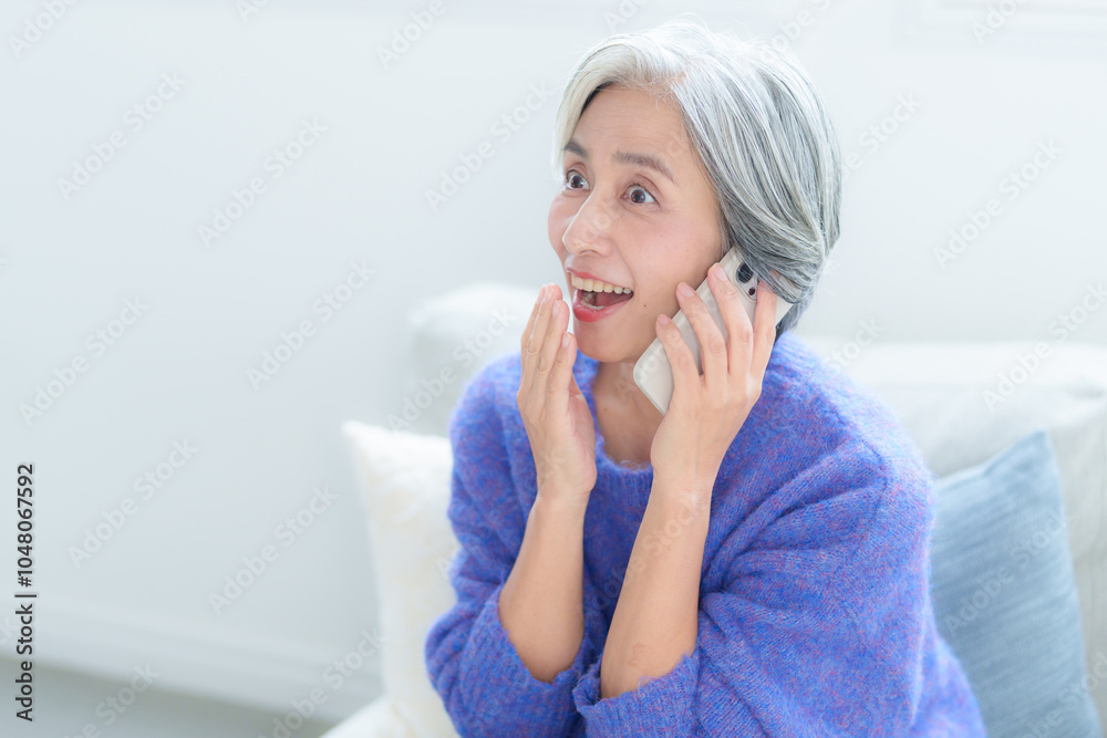スマートフォンで通話をする中高年の女性 スマートフォンで通話をする中高年の女性
