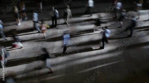 Dynamic movement of people in a busy city at night, with blurred motion creating hustle and bustle