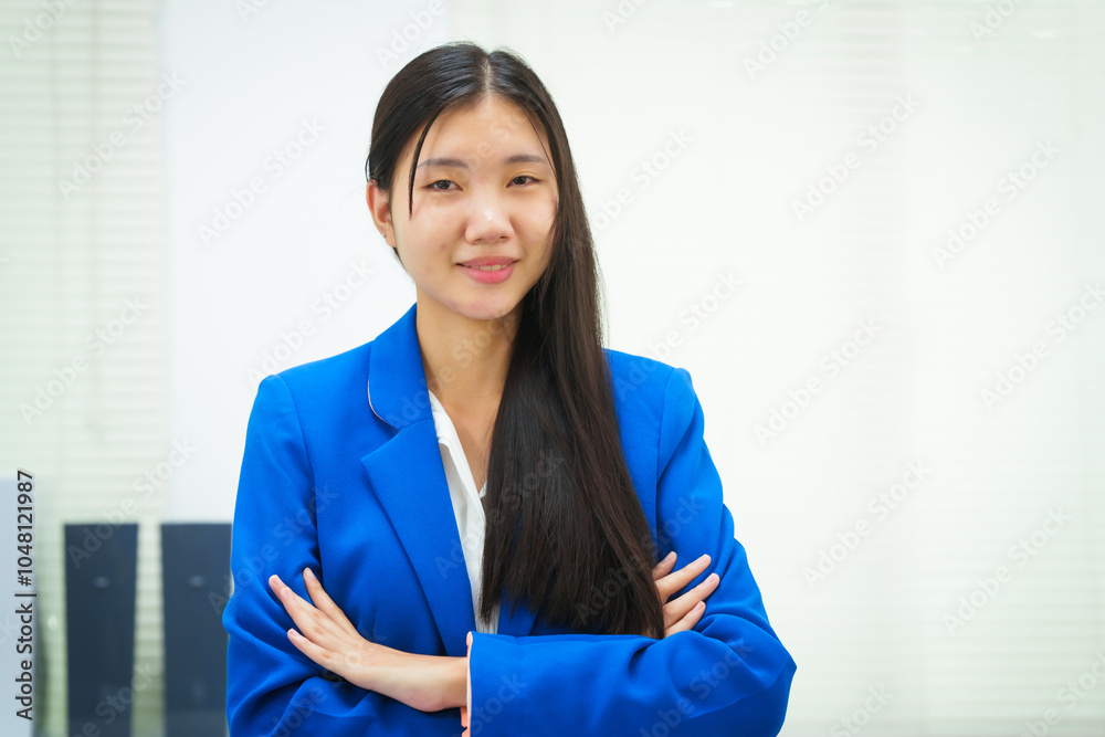 A confident businesswoman stands at her desk in the office, smiling with her arms crossed. Her positive demeanor reflects her satisfaction and pride in her work and the company's achievements A confident businesswoman stands at her desk in the office, smiling with her arms crossed. Her positive demeanor reflects her satisfaction and pride in her work and the company's achievements