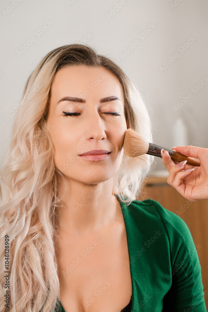 Obraz premium A stylist makes a woman's makeup