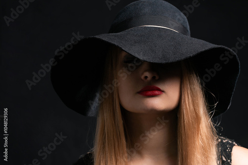 A woman wearing a black hat and red lipstick