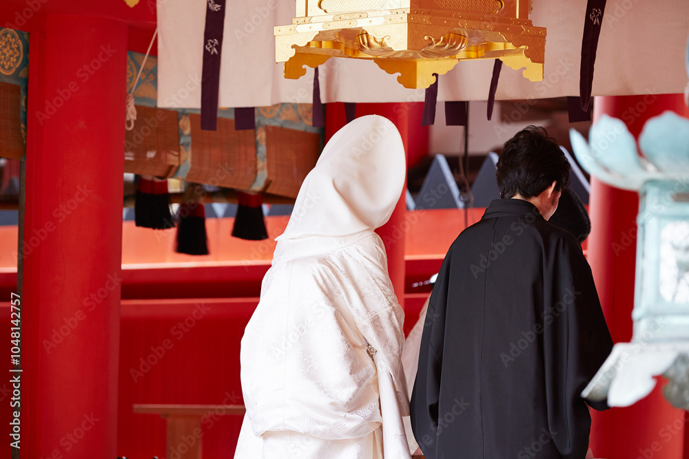 Fototapeta premium Back view of a man and woman getting married at a Japanese shrine