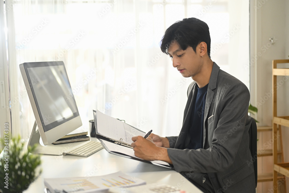 Concentrated businessman working with business reports and data at office Concentrated businessman working with business reports and data at office