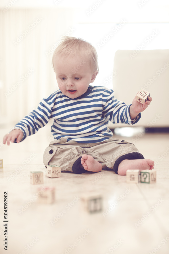 Toddler, boy and happy with building blocks at apartment with toys, fun and learning for child growth. Baby, kid and smile with educational games for brain or language development at living room Toddler, boy and happy with building blocks at apartment with toys, fun and learning for child growth. Baby, kid and smile with educational games for brain or language development at living room