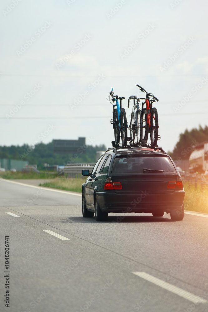 Naklejka premium Car carrying bicycles on a busy highway road