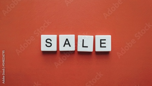 Four white square tiles with black letters spelling the word SALE are arranged horizontally on a red background.