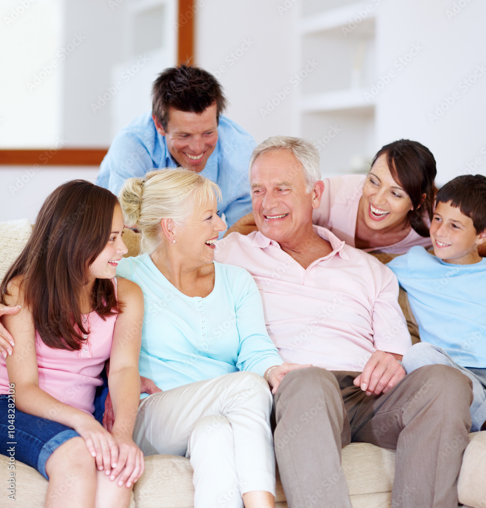 Laughing, home and parents with children and grandparents together with care on sofa. Family generations, happy and smile with love, bonding and support with hug relax in living room on weekend Laughing, home and parents with children and grandparents together with care on sofa. Family generations, happy and smile with love, bonding and support with hug relax in living room on weekend