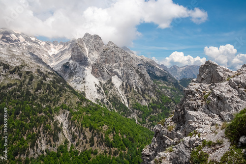 Scenic hiking trail surrounded by majestic steep mountain ridges of Albanian Alps (Accursed Mountains). Crossing high altitude pass between Valbone Valley and Thethi National Park, Albania. Wanderlust